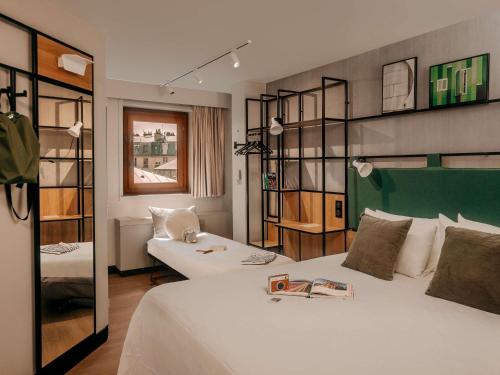a hotel room with a bed and a couch at ibis Paris Bastille Opera in Paris