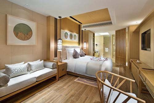 a hotel room with a bed and a couch at Wyndham Grand Plaza Royale Wenchang in Wenchang