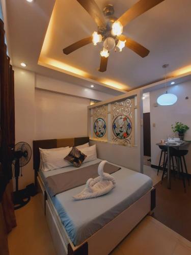 a bedroom with a bed with a ceiling fan at Cozy Corner Haven near Venice Grand Canal Mall in Manila