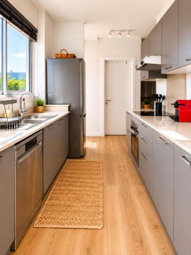 a kitchen with stainless steel appliances and a wooden floor at Blue Zebra - Le West 24 in Tamarin