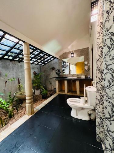 a bathroom with a toilet and a sink at Pavana Hotel Negombo in Negombo