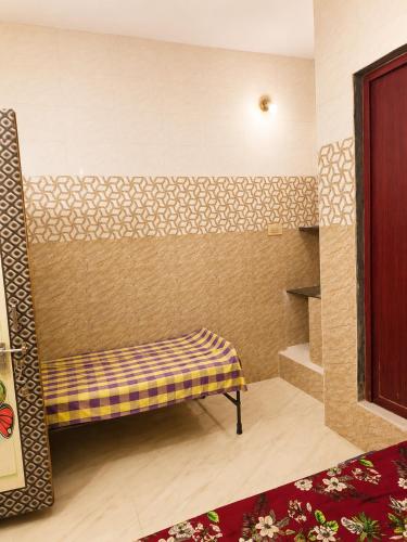 a bench sitting in the corner of a room at C Gowri Lodge in Vellore