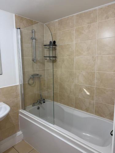 a bathroom with a bath tub and a sink at Elysium pro in Bradford