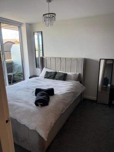 a bedroom with a large white bed with a chandelier at Elysium pro in Bradford