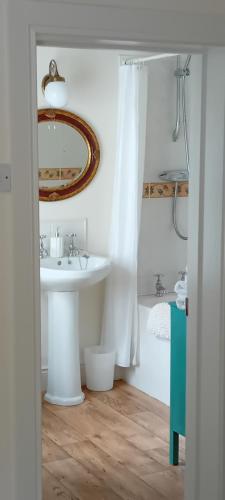 a bathroom with a sink and a mirror at Rose Cottage in Kilrean