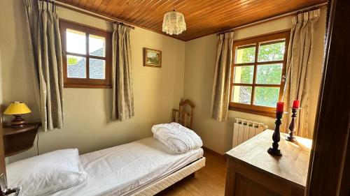 a bedroom with two beds and two windows at Le Gite de la Ferme d Issac in Le Nayrac