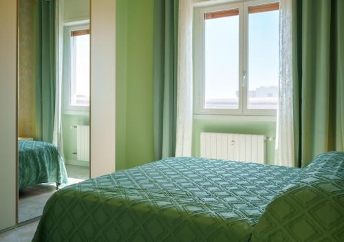a bedroom with a bed and two windows at Casa Thaila - Box auto gratuito in Milan