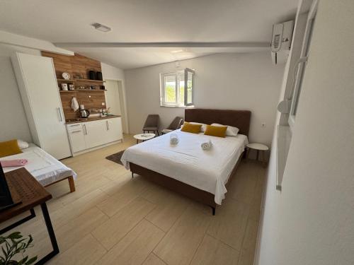 a bedroom with a large bed and a kitchen at Apartment Herceg Blagaj in Blagaj