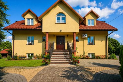 a large yellow house with a red roof at Dworek Julia Komfortowe Pokoje z Klimatyzacją nad Soliną in Polańczyk