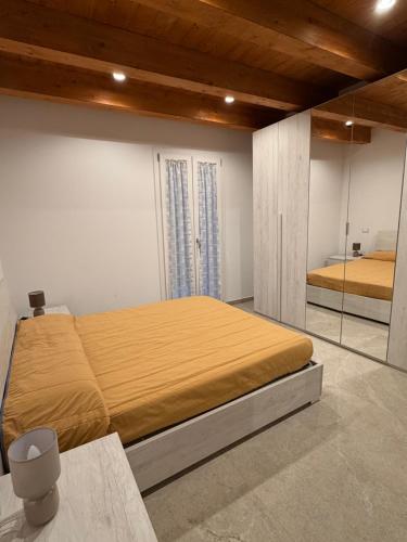 a bedroom with a large bed with a mirror at Casa Alfio in Centobuchi