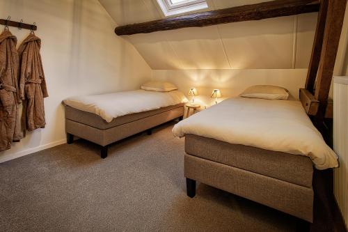 a room with two beds and a chair in it at Hotel Hoeve de Plei in Mechelen