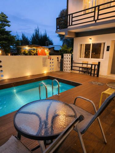 a patio with a table and chairs next to a swimming pool at Nangkam Boutique House in Ko Phi