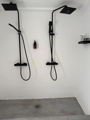 a white wall with three shower systems on it at St Pauls Batsi in Batsi