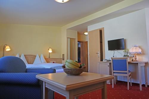 ein Hotelzimmer mit einem Sofa und einem Tisch in der Unterkunft Hotel - Restaurant Gosauerhof in Gosau
