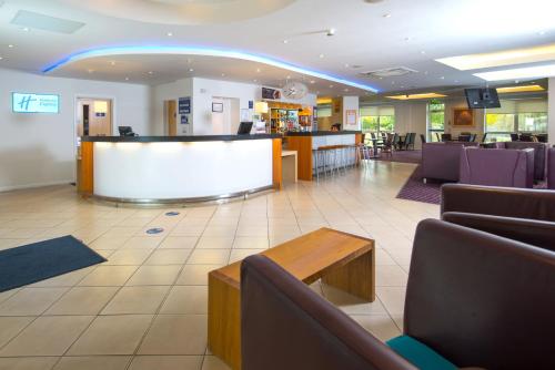 a lobby with a waiting area with chairs and a table at Holiday Inn Express Bedford by IHG in Bedford
