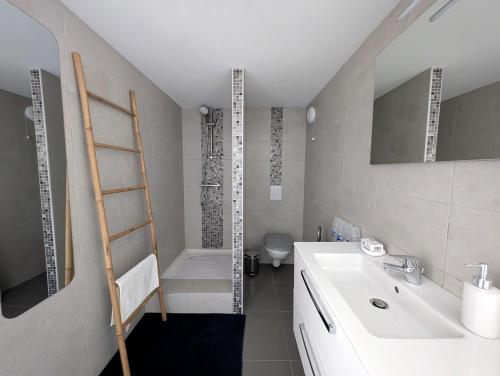 a bathroom with a white sink and a toilet at Chez Laurence et Thomas in Cercié