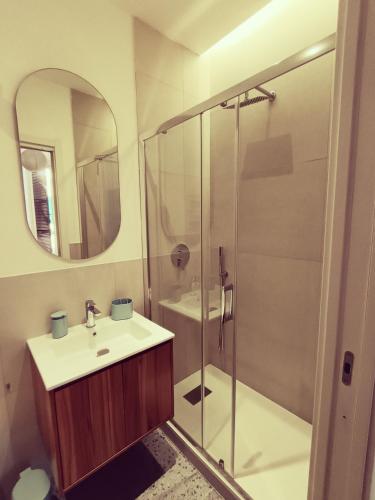 a bathroom with a shower and a sink and a mirror at Studio64 in Civitavecchia