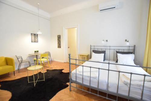 1 dormitorio con 1 cama, mesa y sillas en Standard Apartment by Hi5 - Chainbridge, en Budapest