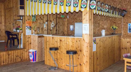 a wooden bar with stools in a restaurant at Norbergs Camping in Norberg