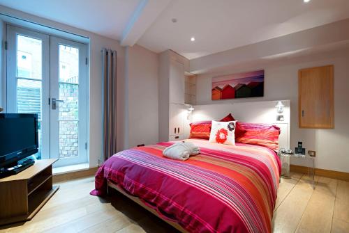 a bedroom with a large bed and a tv at HomefromHolme St Peters Mews in St. Albans