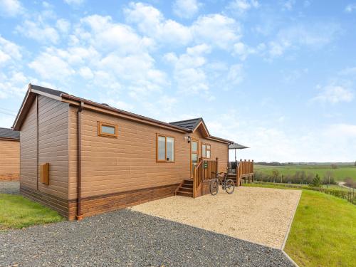 a small wooden house with a bike in front of it at Park View - Uk46898 in Kinlet