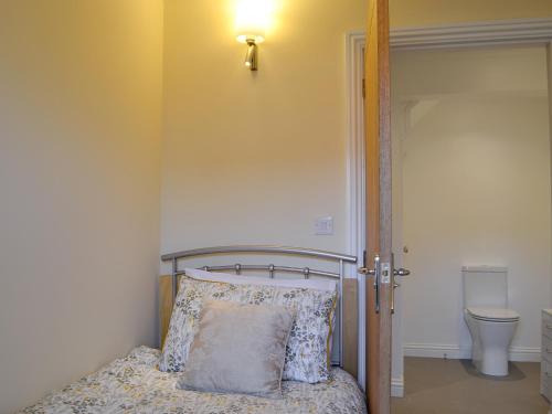 a bedroom with a bed and a light on the wall at Penmaen in Talgarth