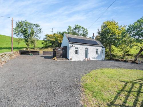 a small white house with a gravel driveway at Lincumtoy in Pinwherry
