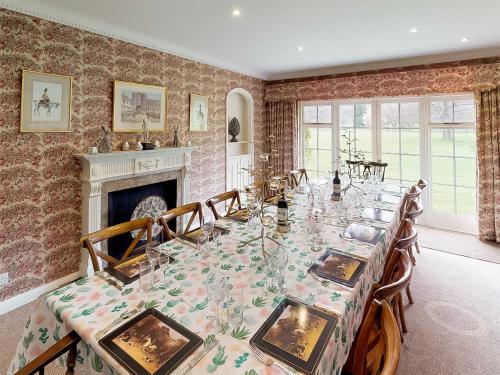 a dining room with a long table and a fireplace at Glanusk Lodge - Uk46654 in Crickhowell