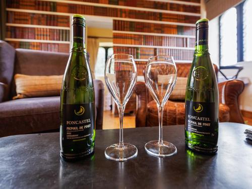 two bottles of wine sitting on a table with glasses at The Tower - Uk46652 in Crickhowell