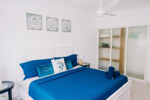 a bedroom with a blue bed with blue pillows at 3 Min Walk to Bibijagua Beach - Spacious 2BR in Punta Cana