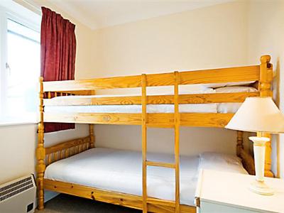 a bedroom with two bunk beds and a lamp at Trebah - B5623 in Saint Cleer