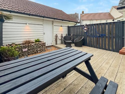 a wooden bench sitting on a wooden deck at Dory in Rye