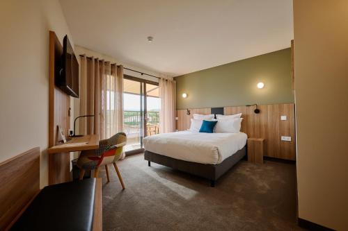 a hotel room with a bed and a desk and a television at Hôtel La Perna in Pernes-les-Fontaines