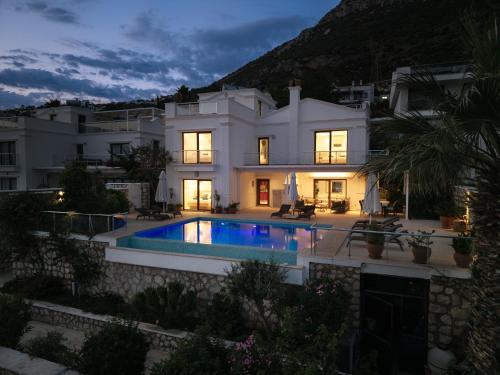 a villa with a swimming pool in front of a house at Villa Yakamoz in Kalkan