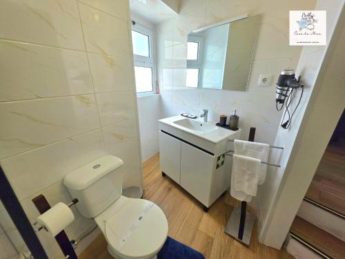 a bathroom with a white toilet and a sink at Casa da Mica in Faja Grande