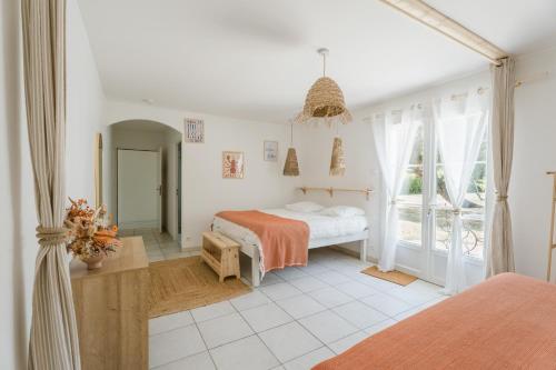 a white bedroom with a bed and a window at Villa Sarment Oleron in Saint-Pierre-dʼOléron