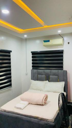 a bed with a pink pillow on it in a room at Lazeto Hotel & Resort in Zokoja