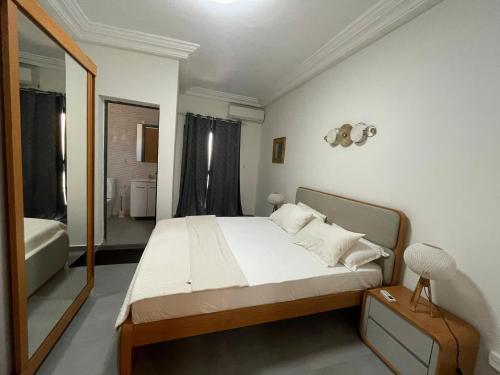 a bedroom with a large bed and a mirror at Mamelle in Dakar