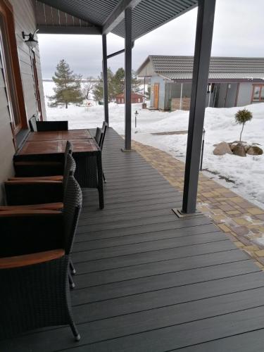 a wooden deck with benches and a table in the snow at Viesu māja Liepas in Rēzekne