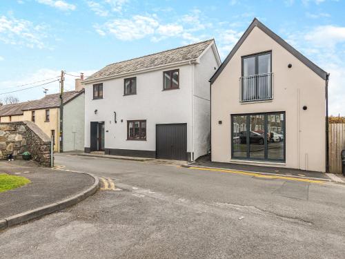 ein weißes Haus mit Garage an einer Straße in der Unterkunft Flat 1 - Uk49037 in Narberth