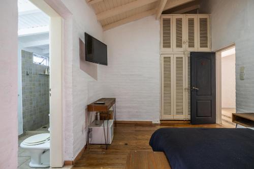 a bedroom with a bed and a tv on a wall at Casa Campo Hotel Boutique - San Pedro in San Pedro