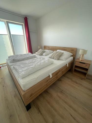 a large bed in a bedroom with a wooden floor at Ferienwohnung Mövenkieker in Kappeln