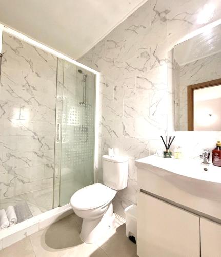 a bathroom with a toilet and a shower and a sink at Retiro dos Batudes in Palmela