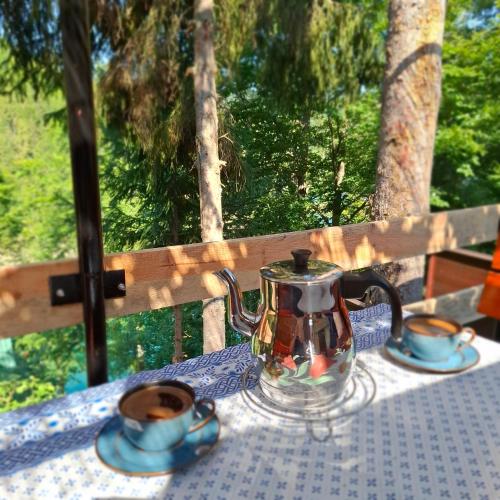 a tea kettle and two cups on a table at Vikendica Breza 2 in Zaovine