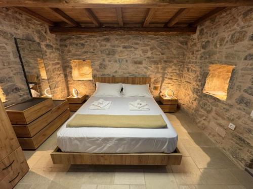 a bedroom with a bed in a room with stone walls at Casa Di Lithos in Mestá