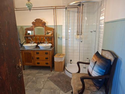 ein Badezimmer mit zwei Waschbecken und einer Dusche in der Unterkunft Van Wyks Hartshuis in Sutherland