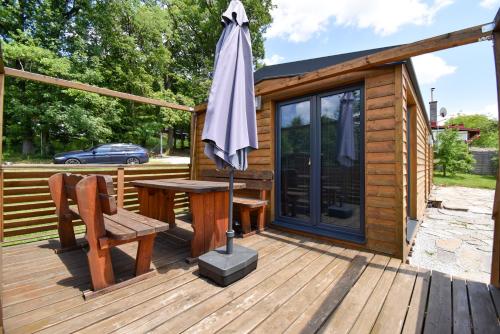 a cabin with a table and an umbrella on a deck at Arktik in Bojnice