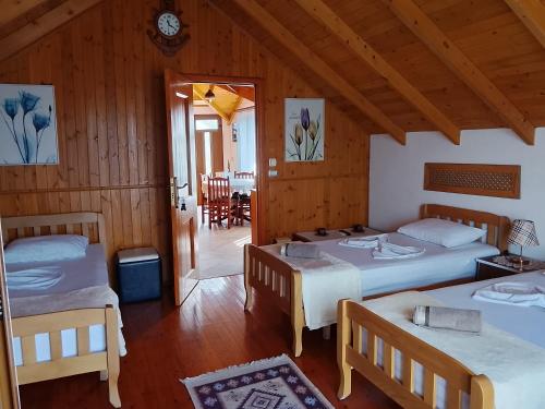 a bedroom with two beds and a dining room at Bixhaku GuestHouse in Gjirokastër