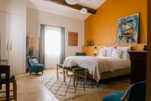 a bedroom with a bed and a table and chairs at MARCELLE EN CAMARGUE - intra muros - piscine et jardin - petit déjeuner compris in Aigues-Mortes
