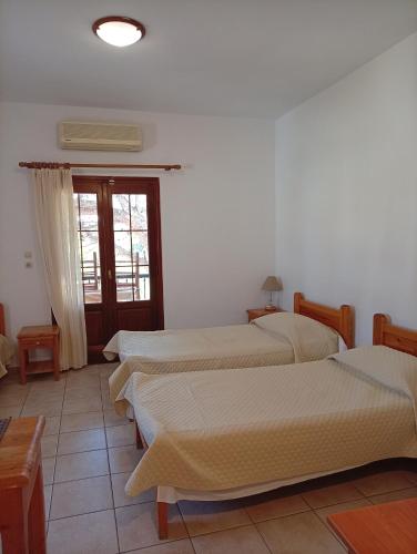 a group of four beds in a room at Benigna Studios in Leipsoi